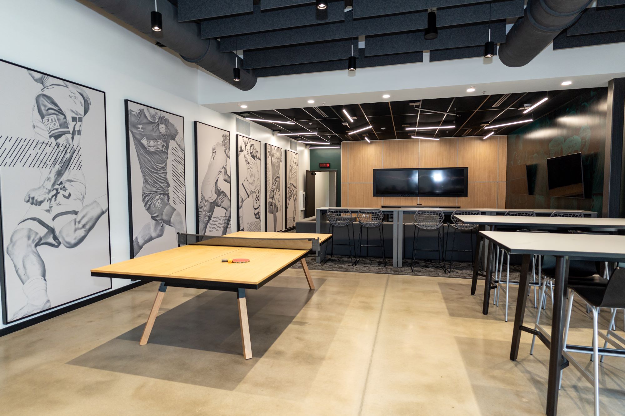 Interior Image of CCFC Player lounge showing ping pong tables, paintings, and tv