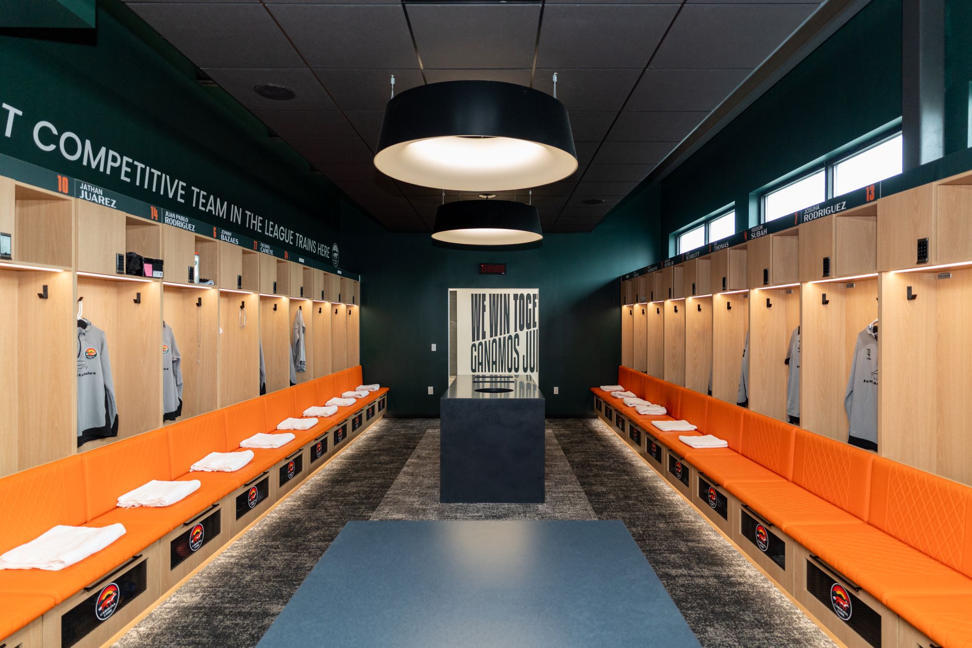 Interior shot of CCFC showing locker room with orange seats and light wood loccers.